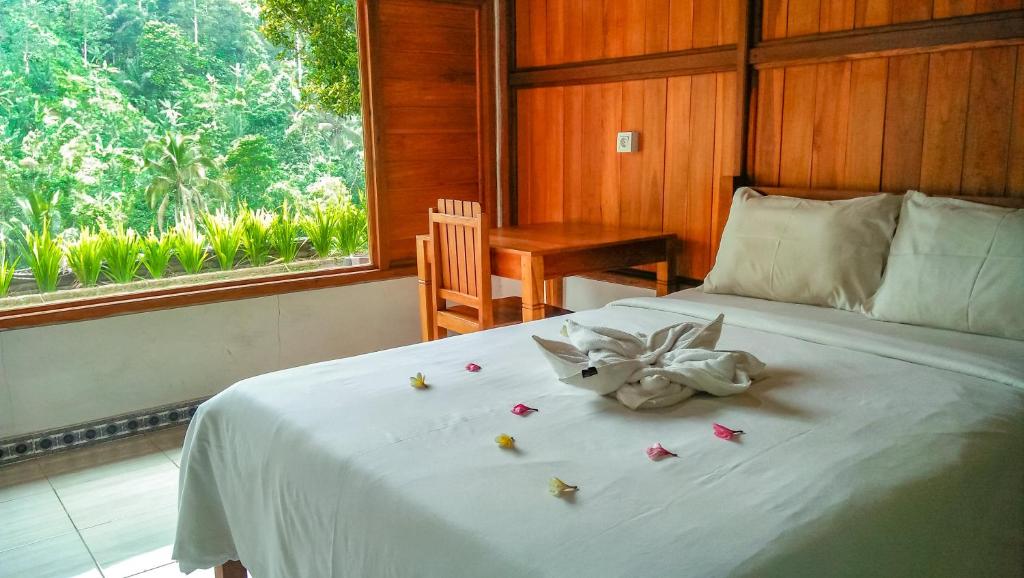 Un dormitorio con una cama con una flor. en Buda's Homestay Lemukih, en Buleleng
