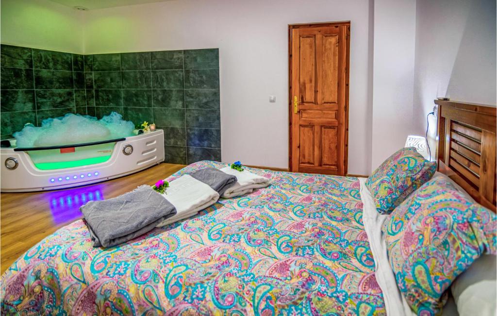 um quarto com uma cama e uma banheira na parede em Beautiful Apartment In La Omauela With 2 Bedrooms And Wifi em La Omañuela