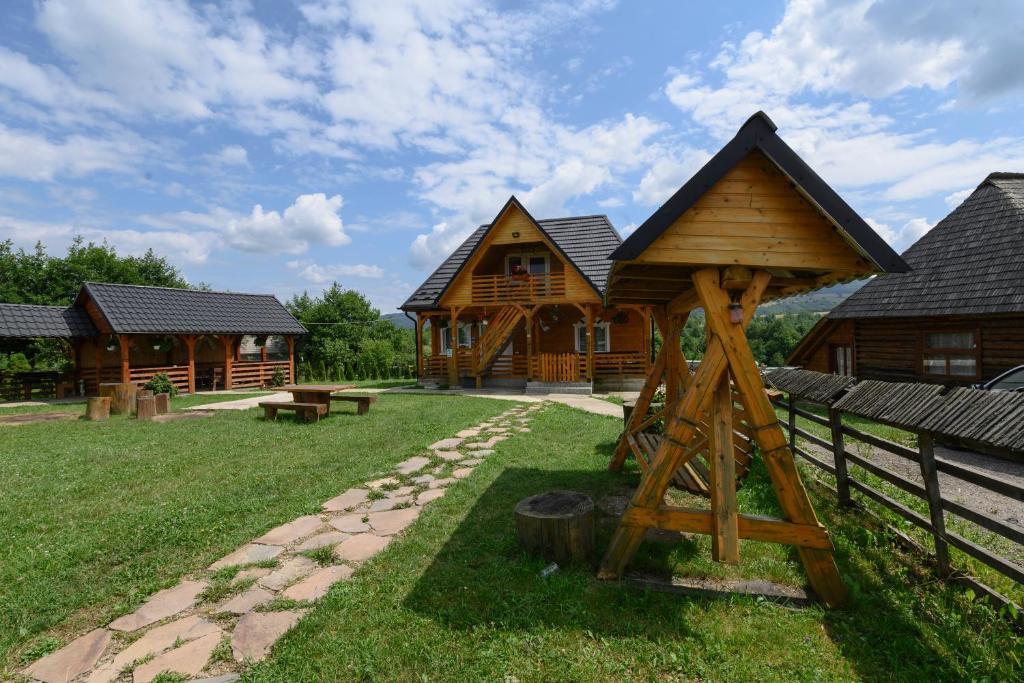 a log cabin with a gazebo in the yard at Casa Cupcea in Budeşti