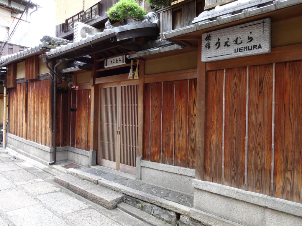 a building with wooden doors and a sign on it at Ryokan Uemura in Kyoto