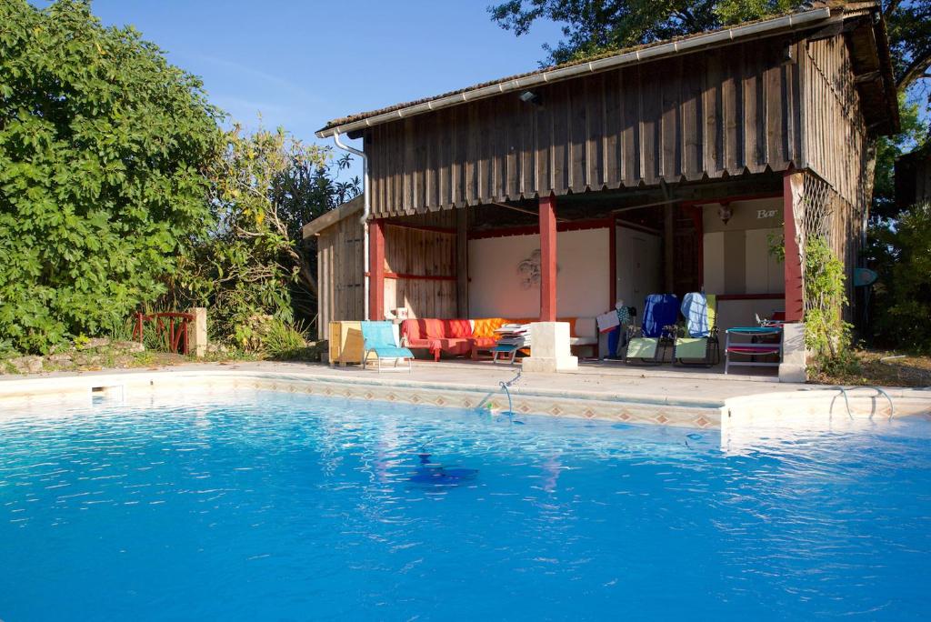 una casa con piscina frente a ella en LA ROULOTTE, en Pondaurat