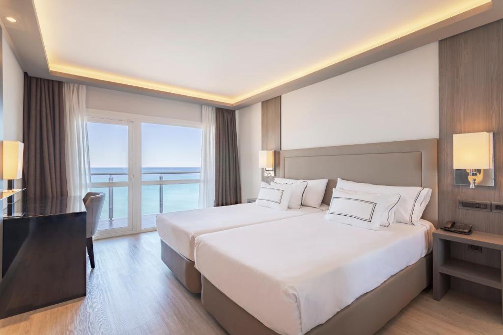 a hotel room with a large bed and a large window at Melia Alicante in Alicante