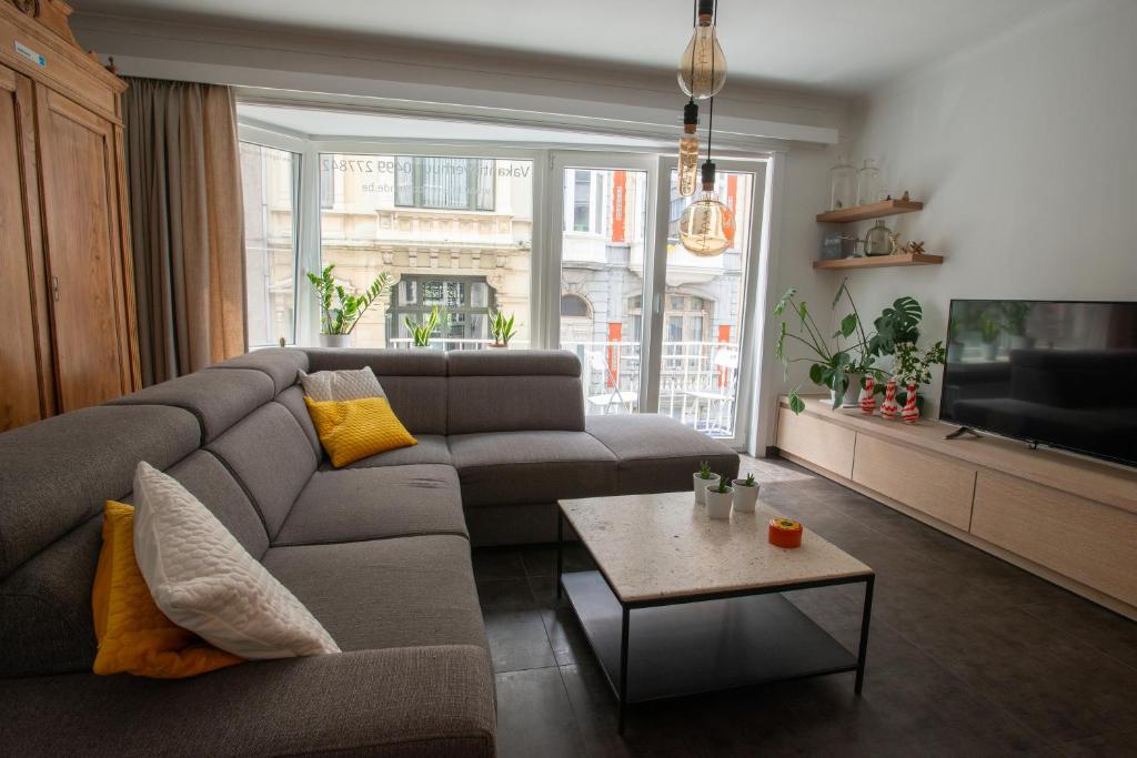 - un salon avec un canapé et une télévision dans l'établissement logerenoostende, à Ostende