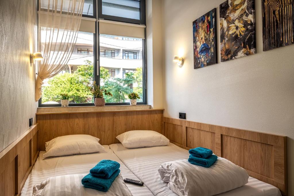 twee bedden in een kamer met twee blauwe handdoeken erop bij HiLoft Hostel in Sotsji