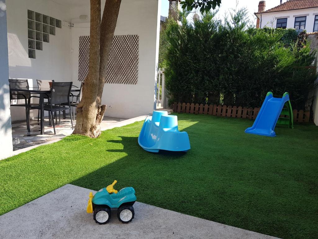 een tuin met twee glijbanen en een speelgoedauto op het gras bij Porto In Sight, 4 Kids in Vila Nova de Gaia