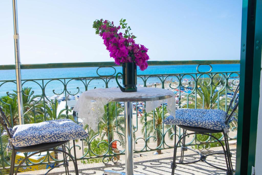 a table with a vase of flowers on a balcony at H11 SEA UNDER THE HOUSE - Arma di Taggia - Liguria in Taggia