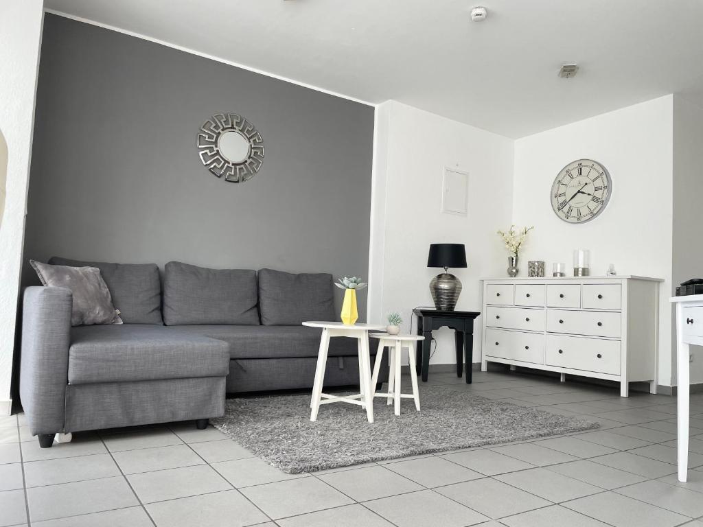 a living room with a gray couch and a table at Innenstadt Neumarkt-Schildergasse stylische Wohnung in Cologne