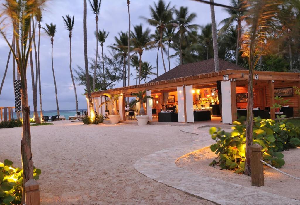 a restaurant on the beach with palm trees at Bavaro Hotel Cortecito in Punta Cana