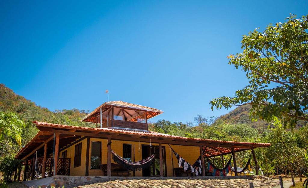 a house with a balcony on top of it at Pousada Varanda da Serra in Cavalcante