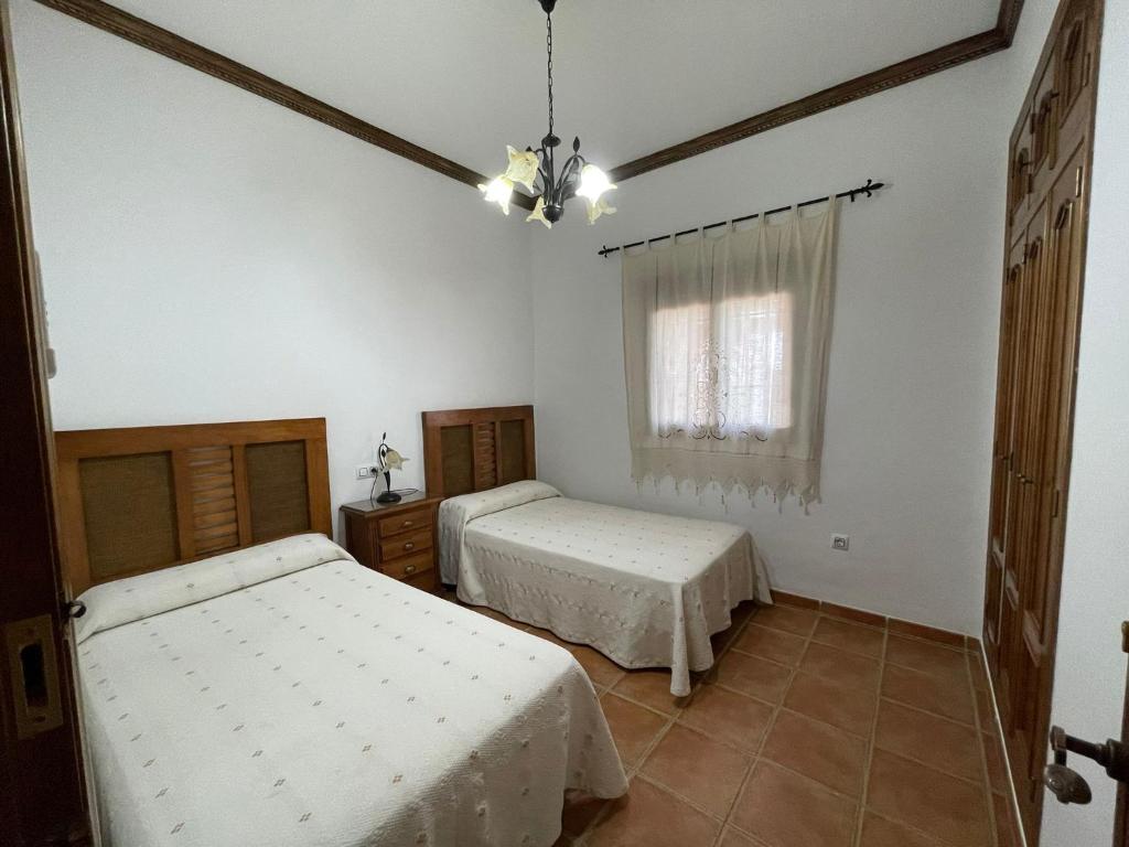 een slaapkamer met 2 bedden en een raam bij Casa Manolín in Córdoba