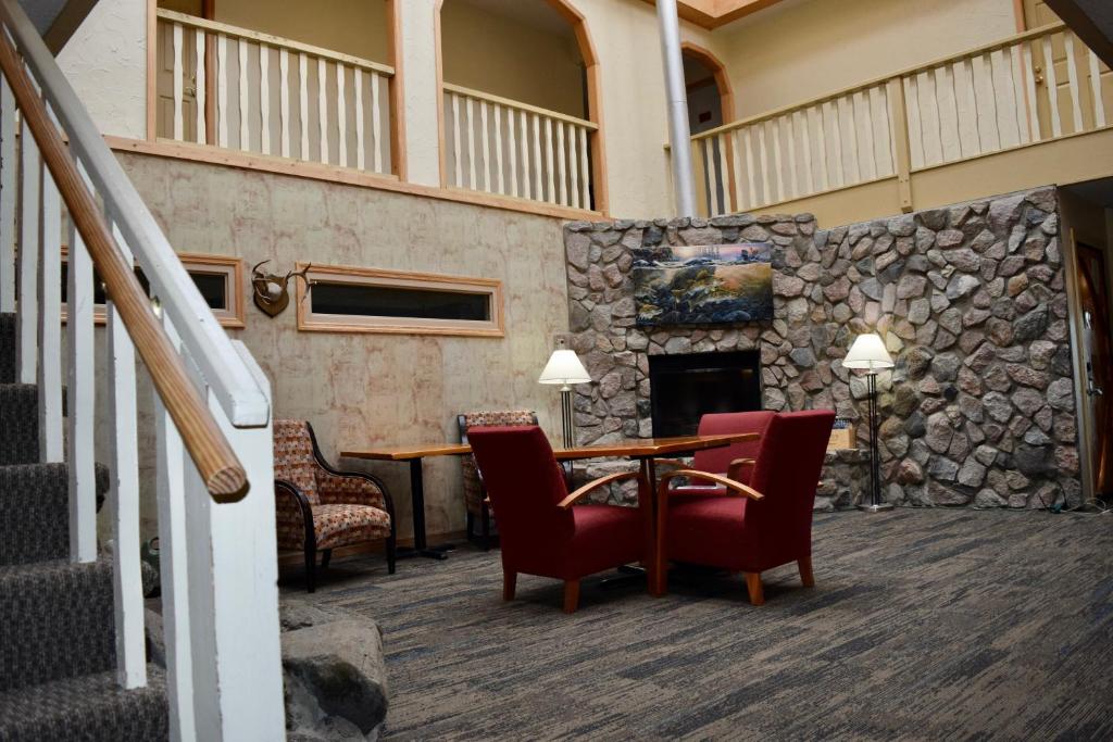 a lobby with a table and chairs and a stone wall at The Otter Lodge in Ottertail