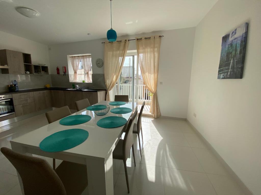 una cucina e una sala da pranzo con tavolo e sedie di Sunshine Apartments Mellieha - modern three bedroom apartment - Apt No 2 a Mellieħa
