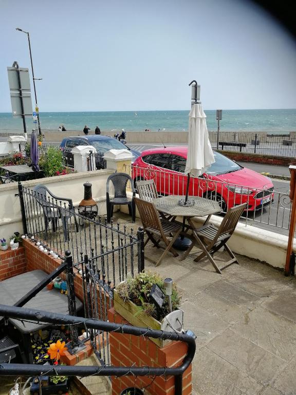 a patio with a table and an umbrella and the beach at Rowntree Seaview Holiday Flats small double room with no view in Bridlington