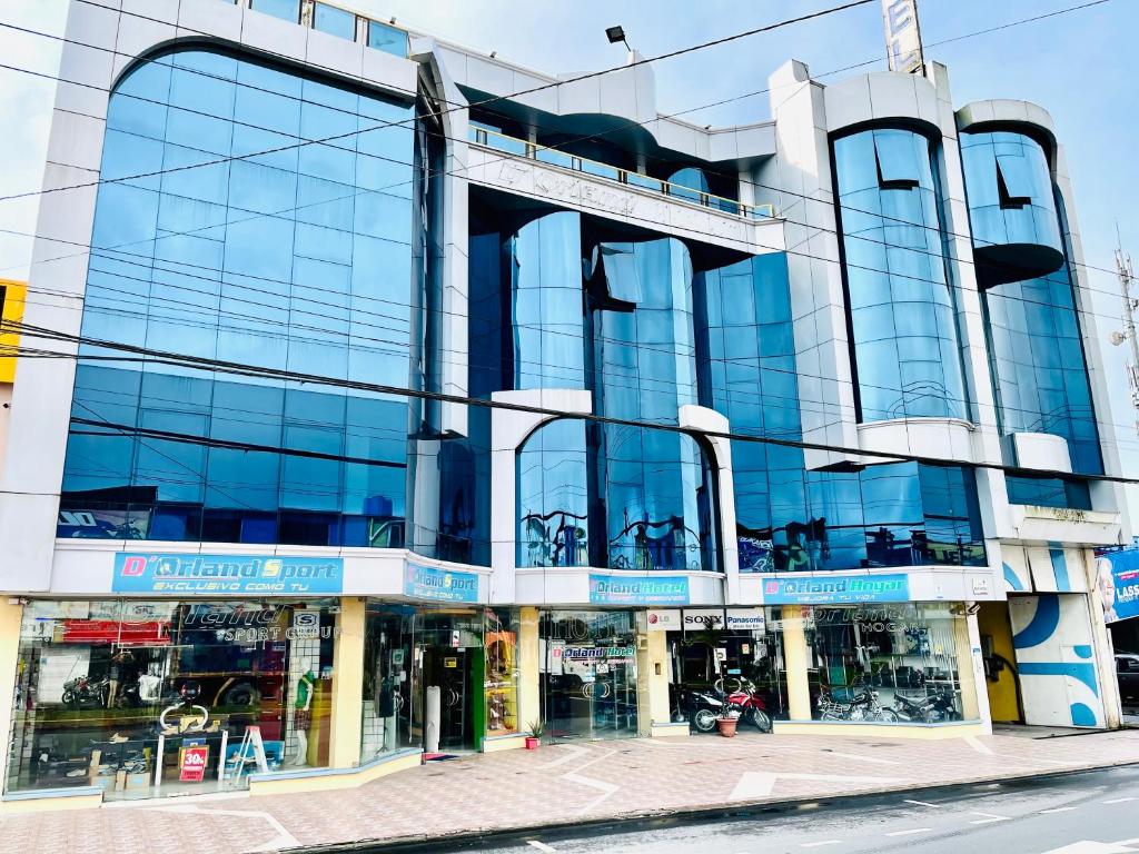 un gran edificio de cristal en una calle de la ciudad en D'ORLAND HOTEL, en Santo Domingo de los Colorados