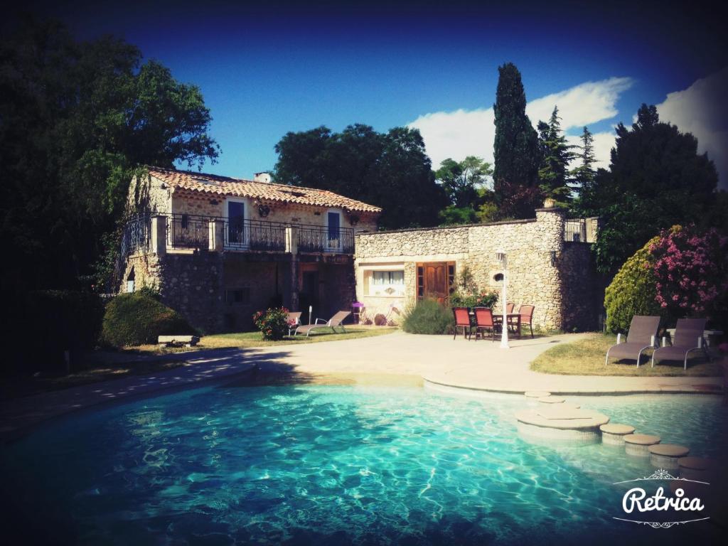 a large pool of water in front of a house at Logis Le Mas de Valaurie in Valaurie