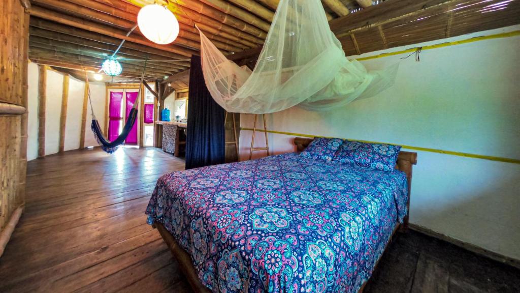 a bedroom with a bed with a mosquito net at Raices Mompiche in Mompiche