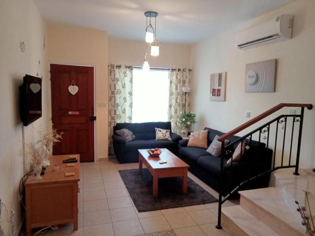 sala de estar con sofá y mesa en No3,23 Neilmmantos St Peyia, en Peyia