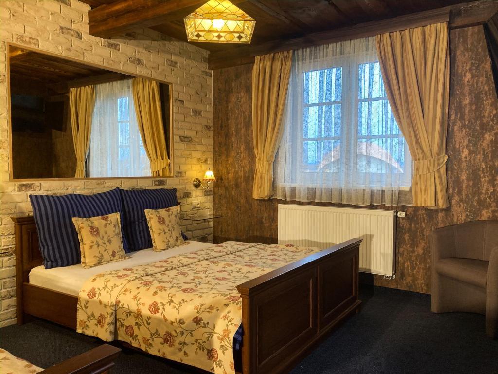 een slaapkamer met een bed en een groot raam bij Penzion Aurooms in Zlatníky