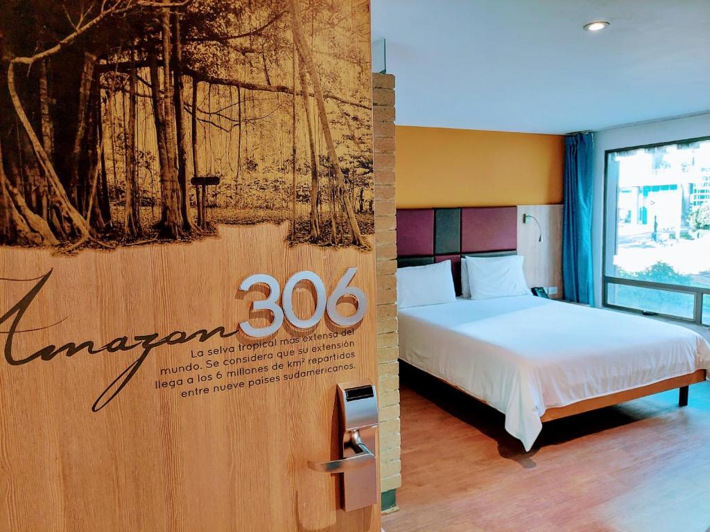 um sinal para um quarto de hotel com uma cama em Hotel Viaggio Teleport City Suites em Bogotá