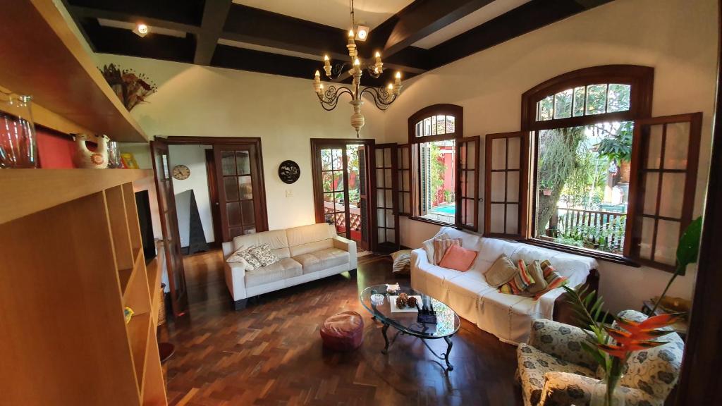 a living room with two couches and a chandelier at Casa Vermelha in Rio de Janeiro