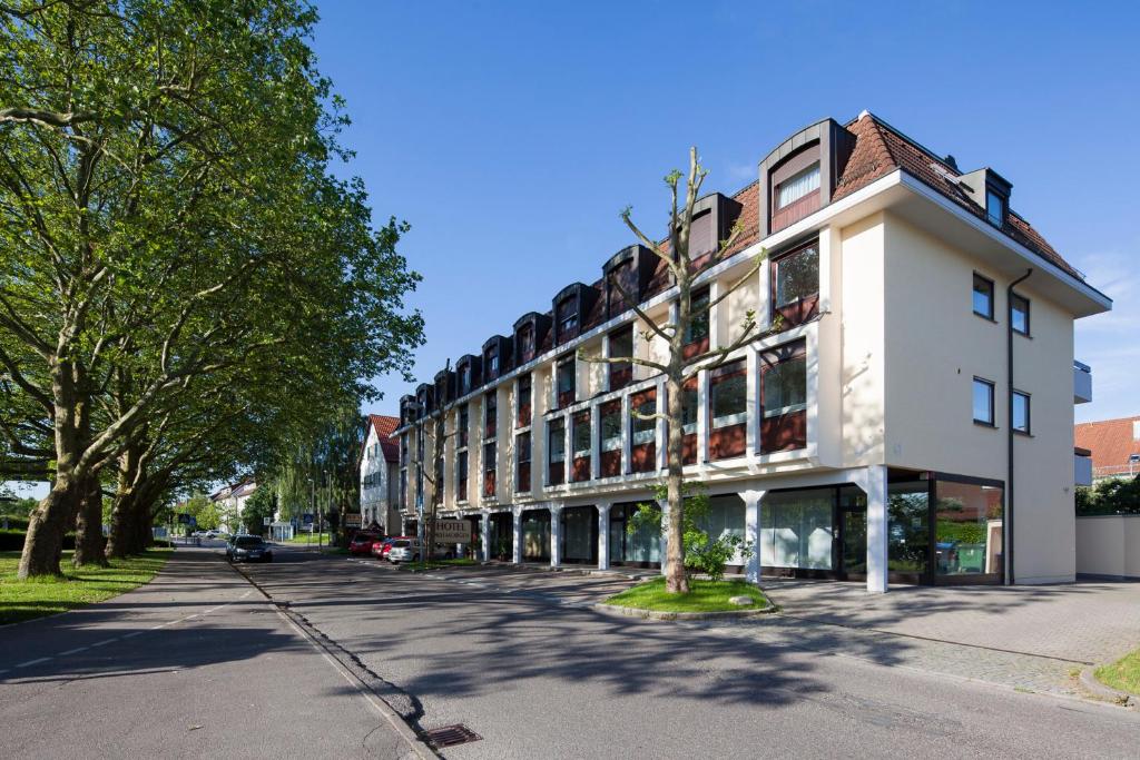 a large white building on the side of a street at Hotel Drei Morgen in Leinfelden-Echterdingen