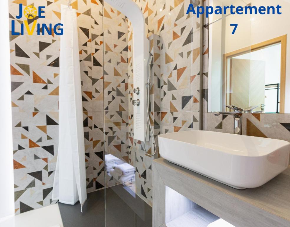 Un baño con un lavabo blanco y un espejo. en Living inStein, en Krems an der Donau
