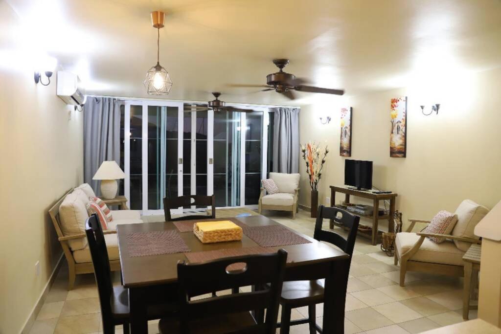 a dining room and living room with a table and chairs at A Beautiful villa in a prime location of Jolly in Jolly Harbour