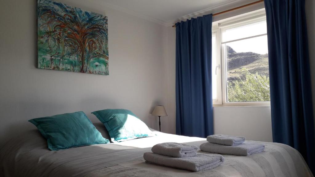 1 dormitorio con 1 cama con toallas en Los Coirones Aparts - El Chaltén - Patagonia en El Chaltén