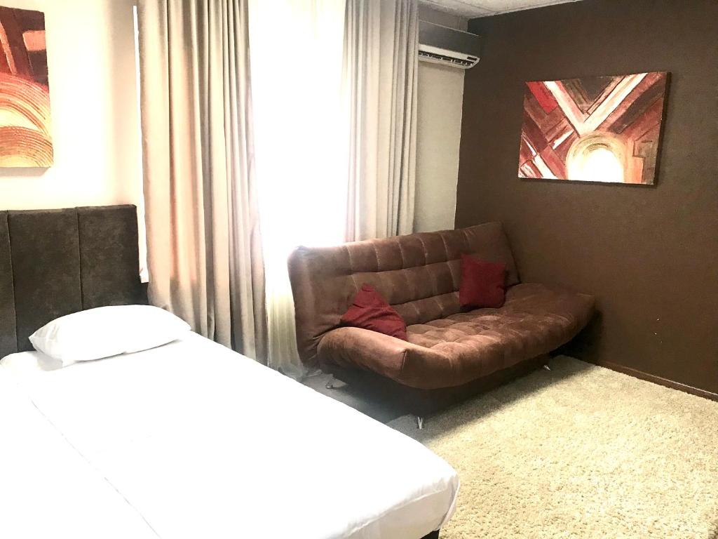 sala de estar con sofá y ventana en Valencia Mini Hotel, en Khabarovsk