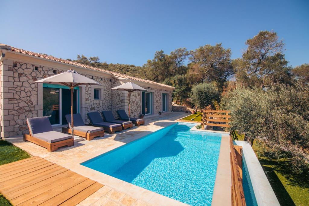uma villa com uma piscina e uma casa em Villa di pietra em Liapades