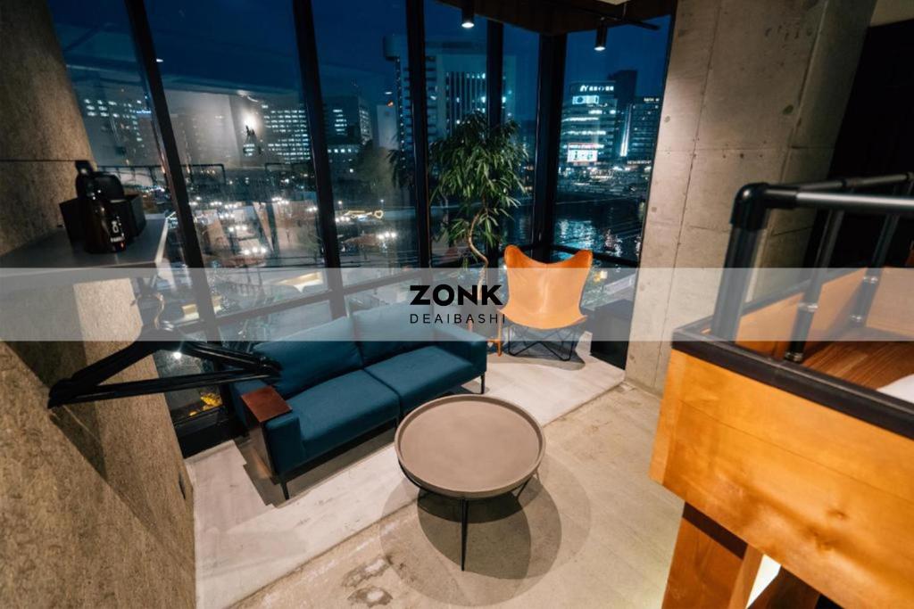 a room with a couch and a table and a window at ZONK HOTEL Nakasu-Deaibashi in Fukuoka