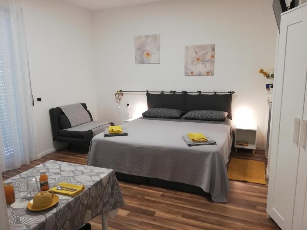 sypialnia z łóżkiem, krzesłem i stołem w obiekcie Cristel malpensa room w mieście Cardano al Campo