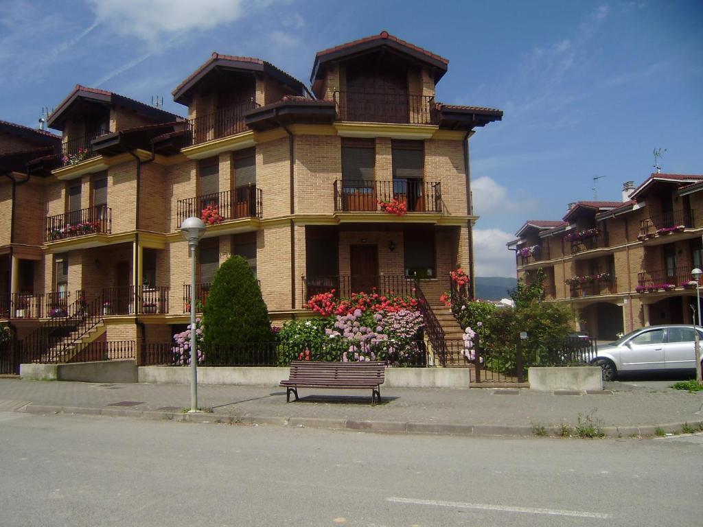 um edifício com um banco à frente em San Pedroko Bidea em Alsasua