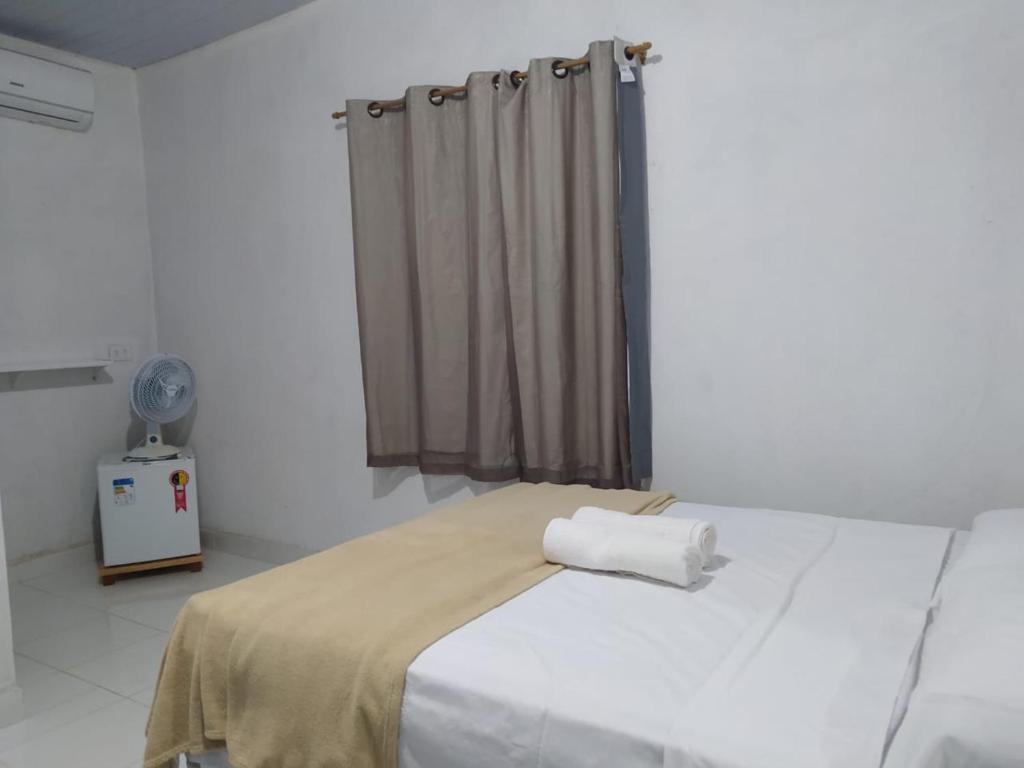a bedroom with a white bed with a curtain at Pousada Águas da Chapada in Carolina