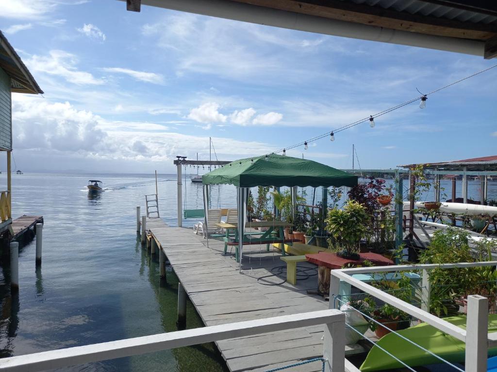 een dok met tafels en stoelen op het water bij Nicol Aparment in Bocas del Toro