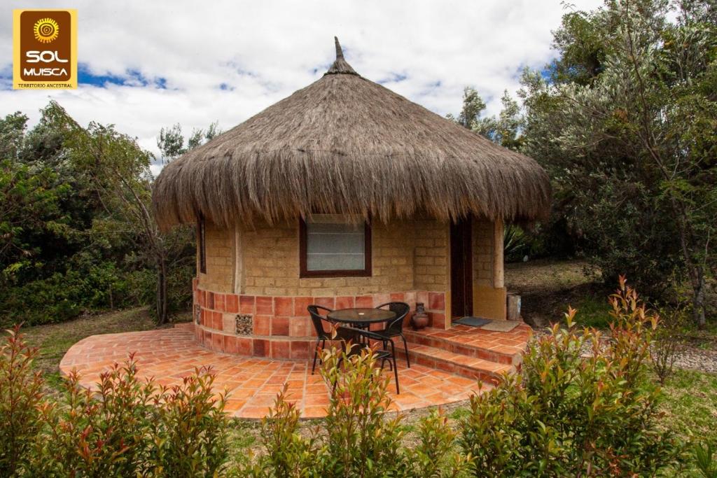 Cabaña pequeña con mesa y techo de hierba en Chalets Sol Muisca RNT85322, en Villa de Leyva