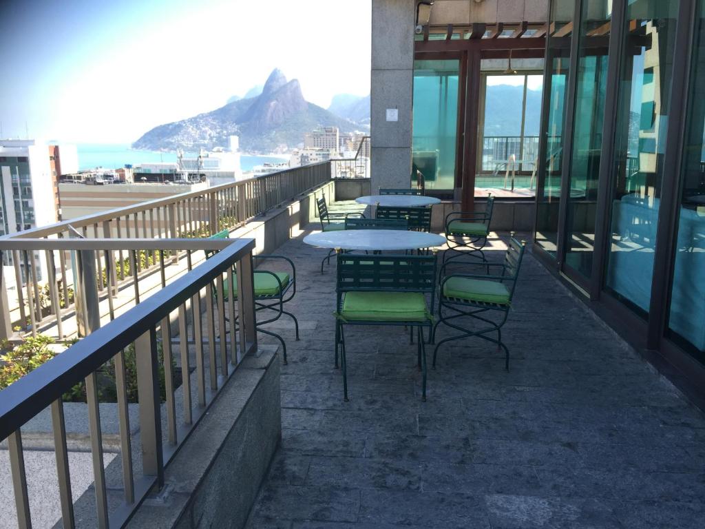 un patio con mesas y sillas en el balcón en TIFFANYS IPANEMA FLATs, en Río de Janeiro
