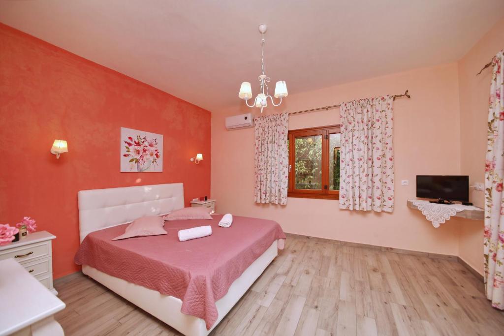 um quarto com uma cama, uma televisão e uma janela em Koromilia Villa em Neo Klima