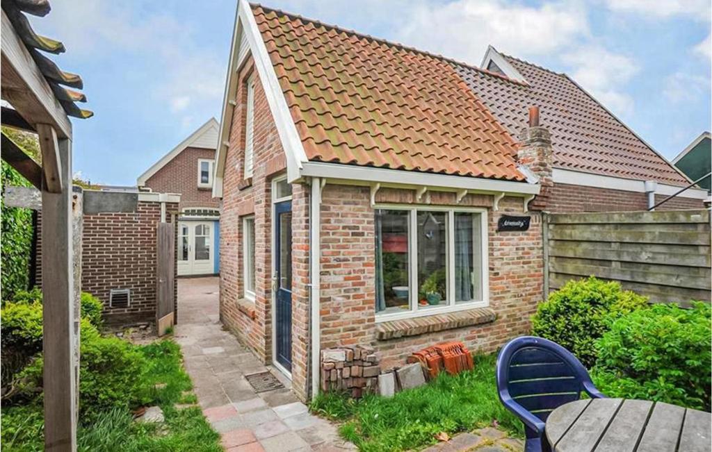 een stenen huis met een tafel en stoelen in de tuin bij Duinviooltje 2 in Bergen aan Zee