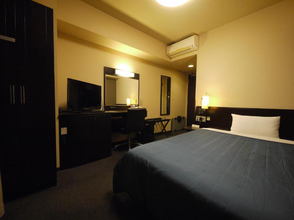 Uma cama ou camas num quarto em Hotel Route-Inn Hofu Ekimae