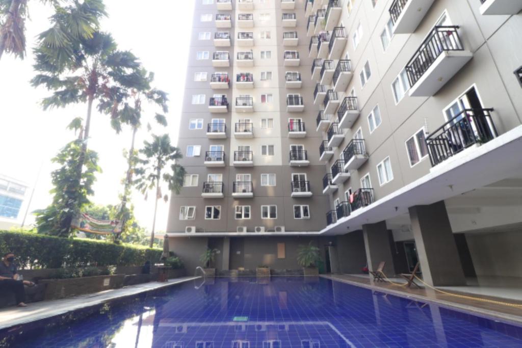 a hotel with a swimming pool in front of a building at Adaru Property at Sunter Park View in Jakarta