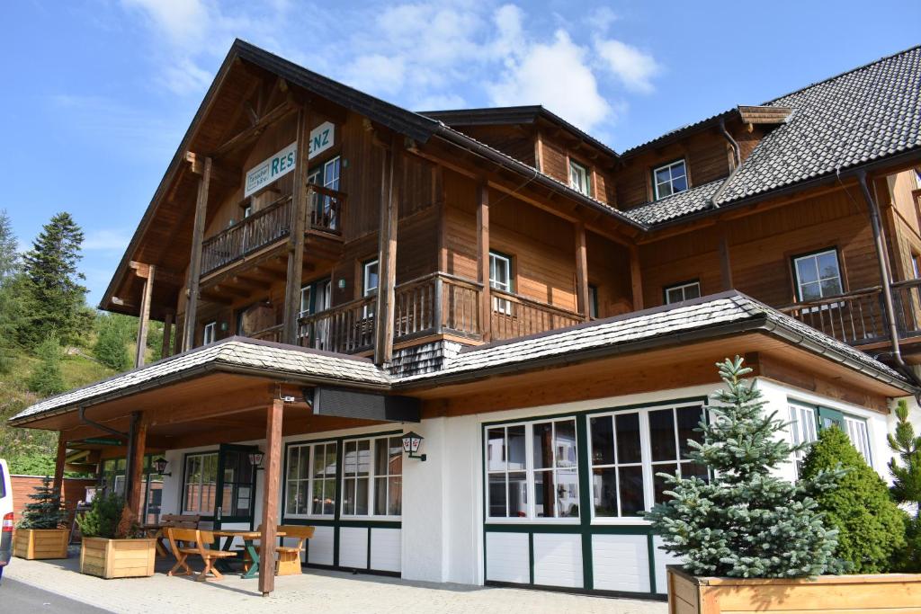 a large wooden house with a balcony at Apartments Alpenpark Turrach by ALPS RESORTS in Brandstätter