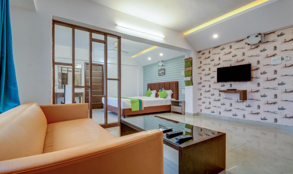 浦那的住宿－Treebo Trend Iris Suites，客厅配有沙发和1张床