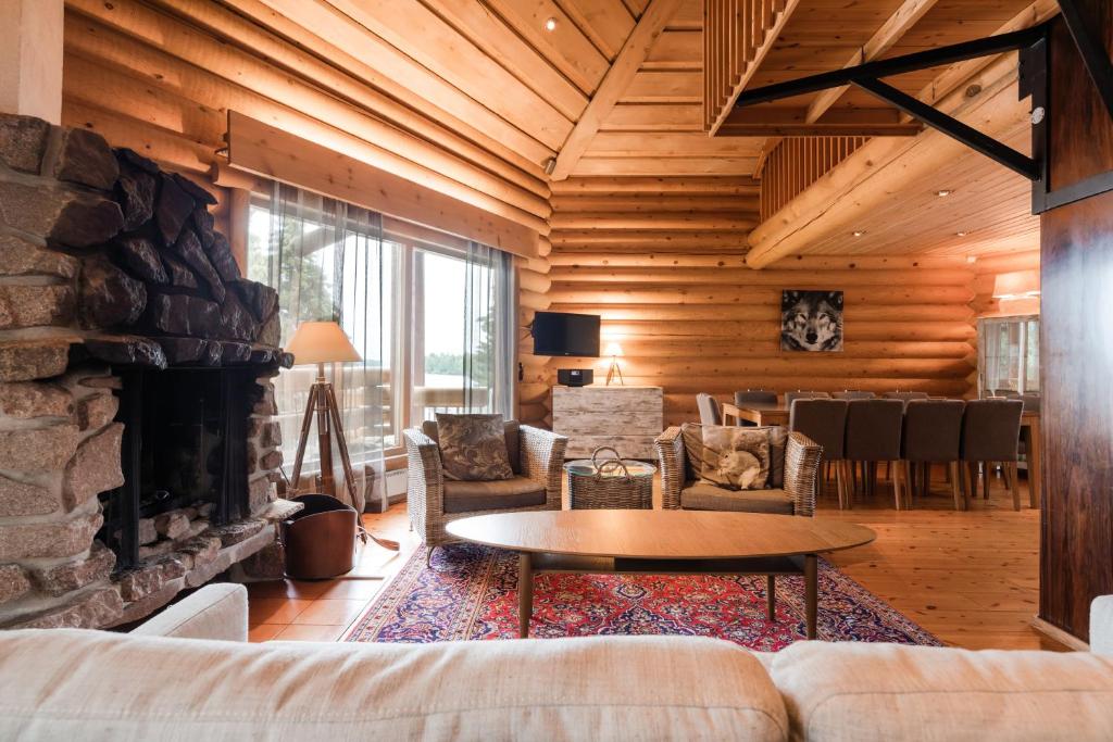 sala de estar con sofá y chimenea en Lapland Hotels Ounasvaara Chalets, en Rovaniemi