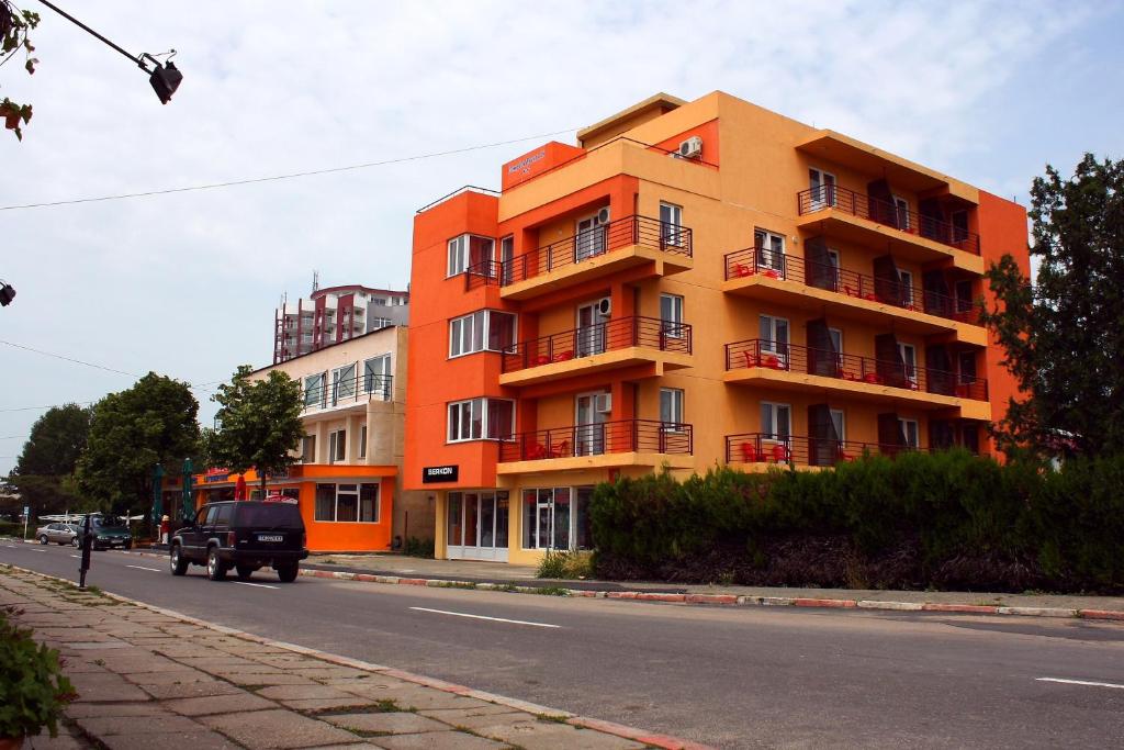 un edificio naranja al lado de una calle en Vila Bucura 19, en Venus