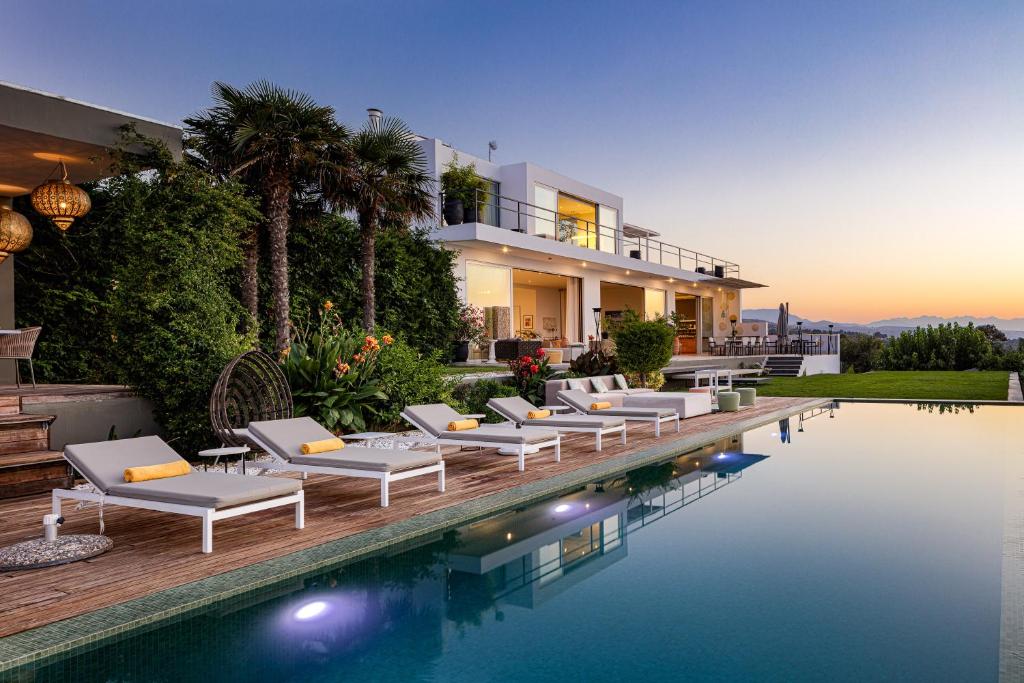 een villa met een zwembad met ligstoelen naast een huis bij Villa Amnalys in Amnátos