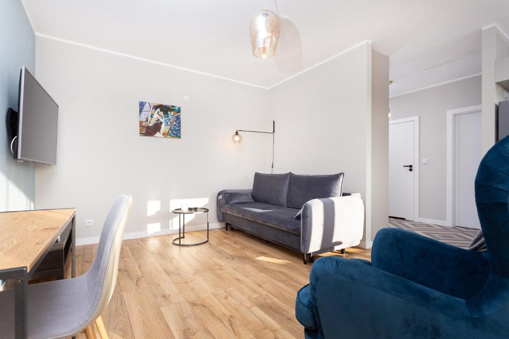 uma sala de estar com um sofá e duas cadeiras em City of the Kings - Indigo Apartment na Cracóvia