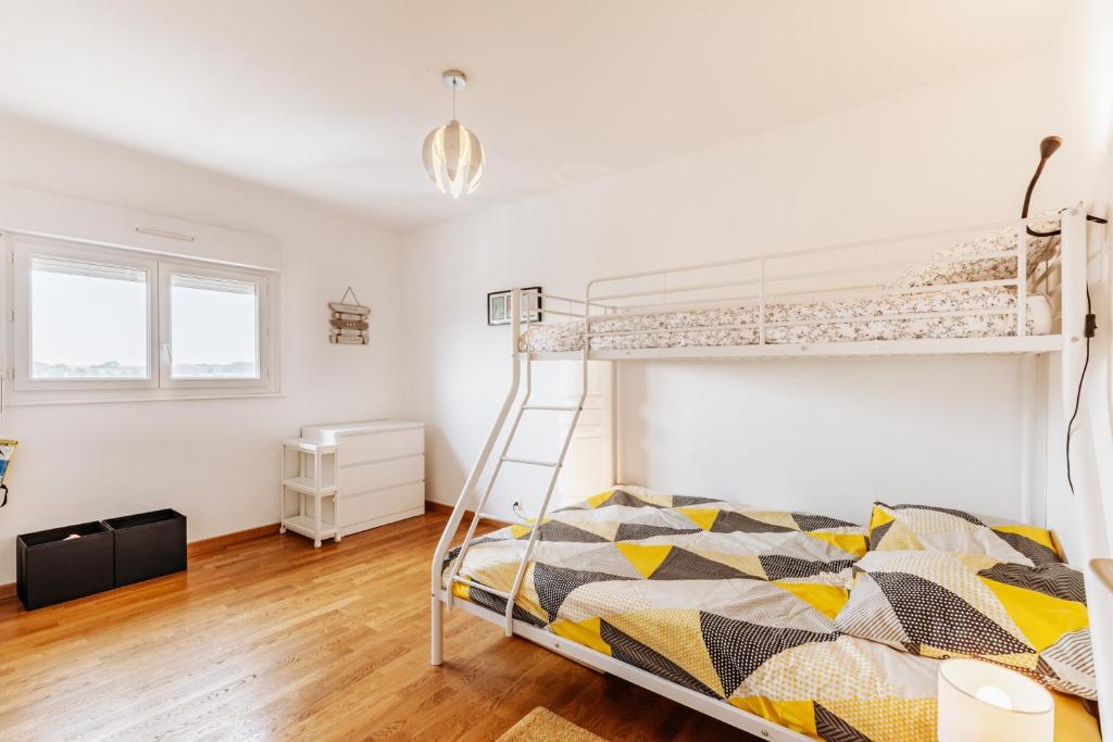 a bedroom with a bunk bed and a ladder at Gwenhen - Appartement vue mer in Courseulles-sur-Mer
