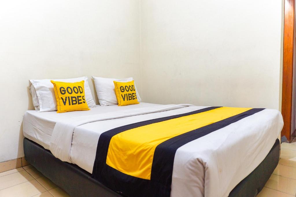 a bed with yellow and black pillows on it at Astria Graha in Bandung