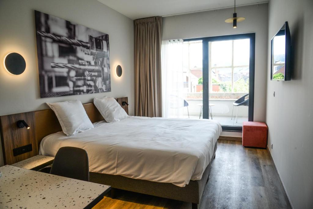 een slaapkamer met een groot bed en een groot raam bij Pegard Andenne Centre in Andenne